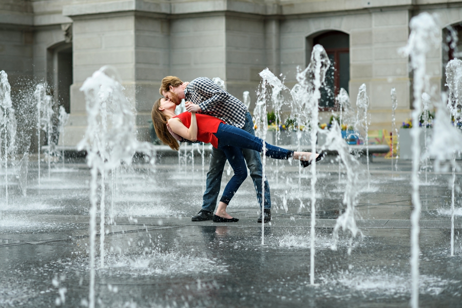 A man dancing with his fiance in the fountain outside of city hall in philadelphia.